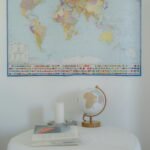 Simple indoor decor featuring a world map, globe, and books on a table.